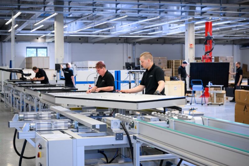 Frauen udn Männer an einer Produktionslinie für PVT-Module bei Sunmaxx.