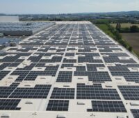 Griße PV-Anlage auf dem Flachdach eines Automobilwerks.