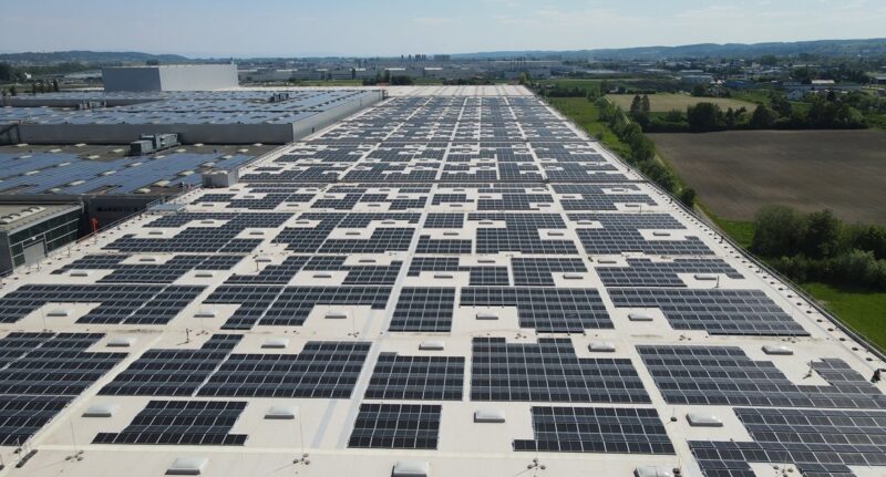 Griße PV-Anlage auf dem Flachdach eines Automobilwerks.