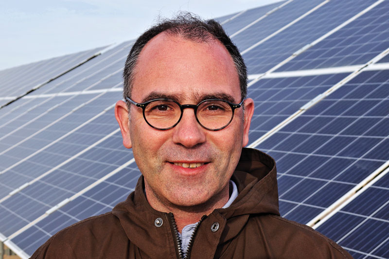 Portrait Sven Neunsinger vor Photovoltaik-Freiflächenanlage in Tunesien.