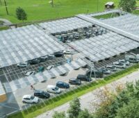 Im Bild eine faltbare Photovoltaik-Anlage über Parkplätze, der Swissolar-Batteriebericht analysiert den Status von PV mit Stromspeichern in der Schweiz.