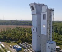 Ein Turm und ein Feld aus Solar-Spiegeln - der DLR-Solarturm mit Synhelion-Receiver.