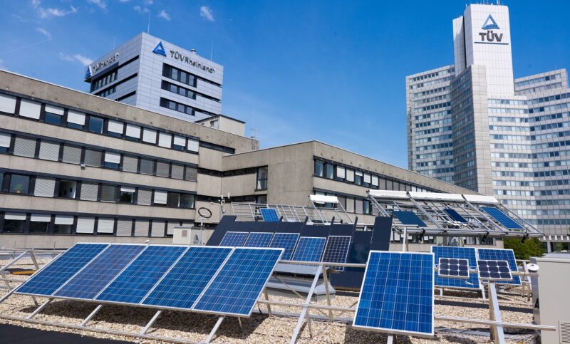 In Bild sind PV-Module auf dem Dach des Gebäudes vom TÜV Rheinland, der Aus- und Weiterbildung in der PV-Branche anbietet.