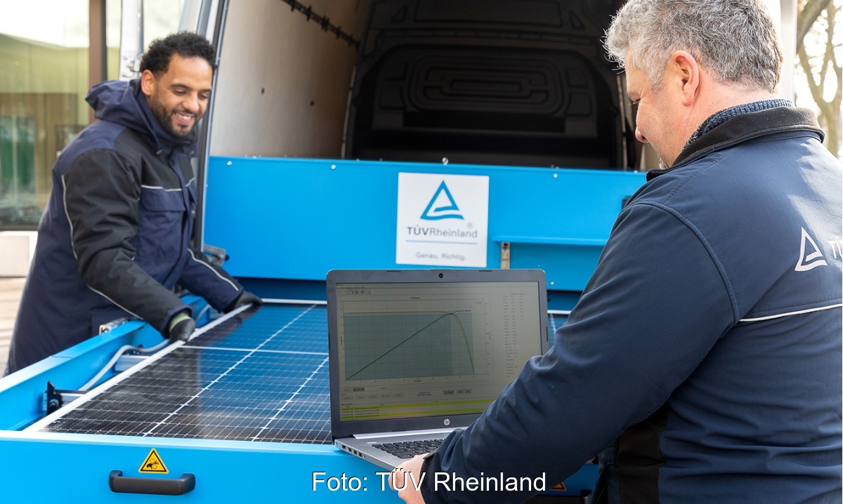 Im Bild zwei Männer, die ein Photovoltaik-Modul im Mobile Solar Lab des TÜV Rheinland testen.
