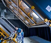 Prüfer analysiert ein PV-Modul unter Sonnenlicht im Labor.