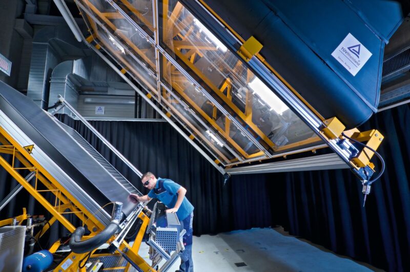 Prüfer analysiert ein PV-Modul unter Sonnenlicht im Labor.