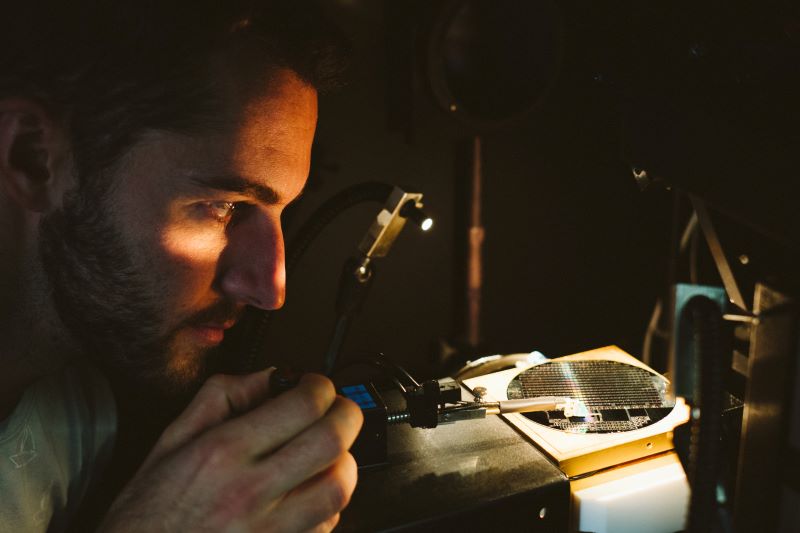 Ein Wissenschaftler betrachtet eine beleuchtete Solarzelle.