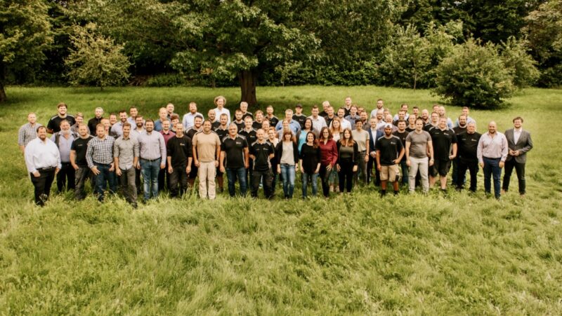 Gruppenfoto auf einer Wiese - das Team des Photovoltaik-Unternehmens Schoenenergie