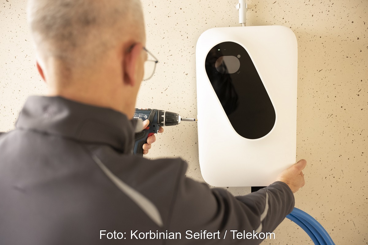 Zu sehen ist ein Monteur der die Ladebox für Elektroautos des Pakets Charging by EnOSTM installiert.