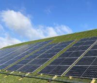 Im Bild sind Photovoltaik-Module, die mit dem Deponie-Solarmontagesystem PowerCap an dem Hang einer Mülldeponie installiert wurden.