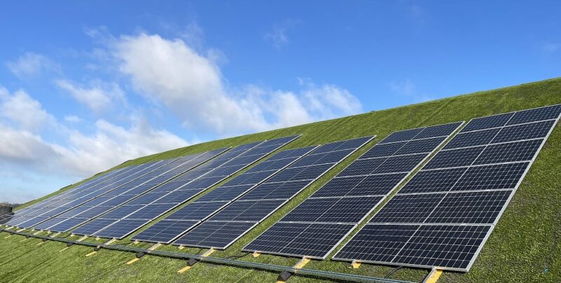 Im Bild sind Photovoltaik-Module, die mit dem Deponie-Solarmontagesystem PowerCap an dem Hang einer Mülldeponie installiert wurden.