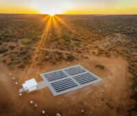 Luftaufnahme von PV-Anlage in Australien mit roter Erde und untergehender Sonne,mit Tesvolt-Batterie-Speicher