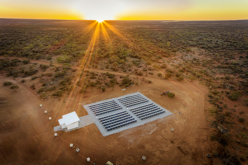 Luftaufnahme von PV-Anlage in Australien mit roter Erde und untergehender Sonne,mit Tesvolt-Batterie-Speicher