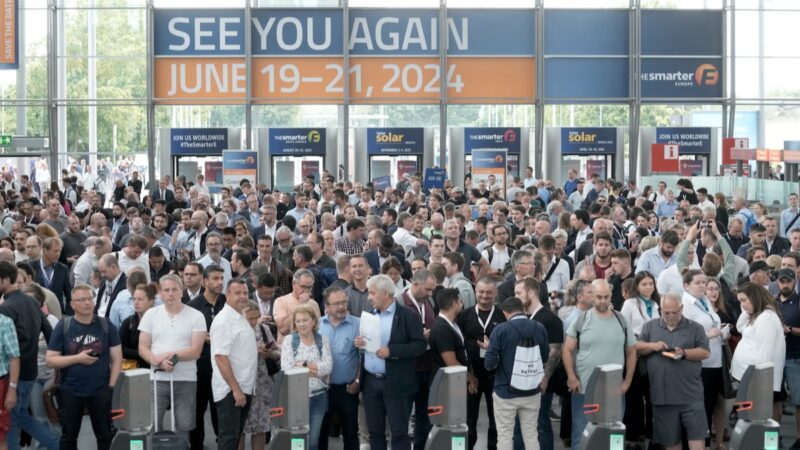 Menschenmasse vor Drehkreuz, oben ein Plakat mit Datum der Messe 2024