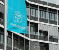 Zu sehen eine Flagge von Thyssenkrupp vor einem Bürogebäude. Thyssenkrupp will Desertec wiederbeleben.