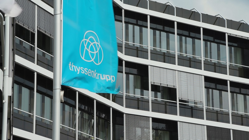 Zu sehen eine Flagge von Thyssenkrupp vor einem Bürogebäude. Thyssenkrupp will Desertec wiederbeleben.