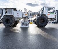 Ein weißer Truck mit dicken Reifen und einer Rüttelplatte unter dem Mittelstück- Erkundung möglicher Geothermie-Standorte am Oberrheingraben