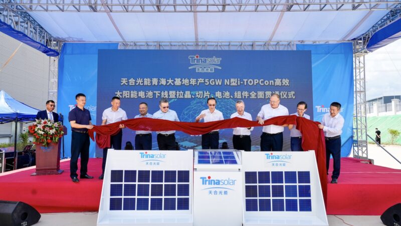 Sieben Männer auf einer Bühne halten eine Schärpe - Eröffnung der PV-Zellen-Produktion von Trina Solar.