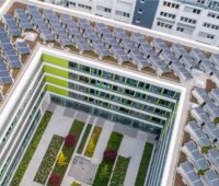 Aufsicht auf ein U-förmiges Gebäude das dicht mit PV-Modulen belegt ist - Tüv PV-Dach-Check soll bei der Beurteilung helfen