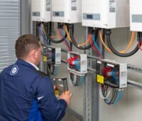 Techniker des TÜV prüft die Wechselrichter von PV-Anlagen.