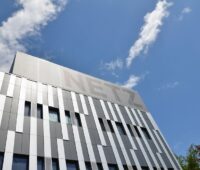 Gebäude mit moderner silberner Fassade und dem Schriftzug Netz gegen blauen Himmel.