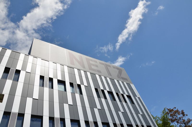 Gebäude mit moderner silberner Fassade und dem Schriftzug Netz gegen blauen Himmel.