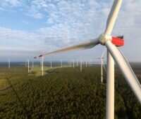 Blick über Windpark im Flachland von Höhe der Nabe einer Windanlage.