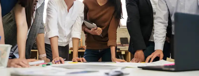 Menschen beugen sich über einen Tisch, Baden-Württemberg will die Wärmeplanung an die Vorgaben des Wärmeplanungsgesetzes anpassen.