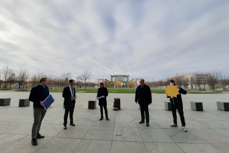 Fünf Personen auf dem Platz vor dem Deutschen Bundestag.