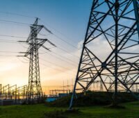 Stromnetze mit Hochspannungsmasten im Bereich eines Umspannwerks bei Sonnenuntergang