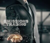 Eine Person streckt die Hand aus, darüber steht Emissions Trading, CO2-Emissionshandel bringt Rekordeinnahmen.