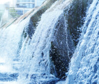 Kaltes, klares Wasser läuft über einen künstlichen Wasserfall in einer Kläranlage.