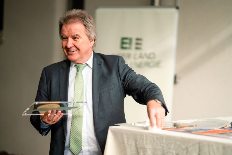 Umweltminister Franz Untersteller überreicht eine Plakette als Auszeichnung.