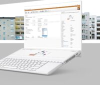 Im Bild ein Laptop vor Gebäuden als Symbol für die Wärmepumpen-Software GeoT*Sol 2024.