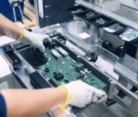 Zwei Hände, Montage eines Batterie-Moduls in der Fabrik von Varta.