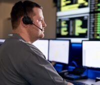 Zwei Männer in einer Kontrollzentrale vor dem Bildschirm, GP Joule übernimmt die technische Betriebsführung von Vattenfall-Photovoltaik-Solarparks.