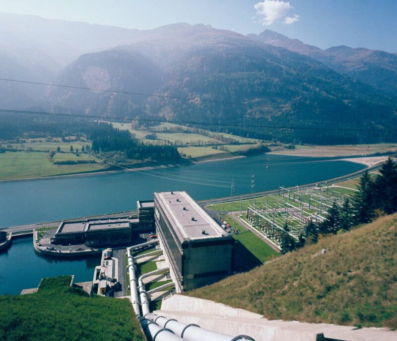 Wasserkraftwerk in den Alpen mit Speichersee und Pumpstationen.