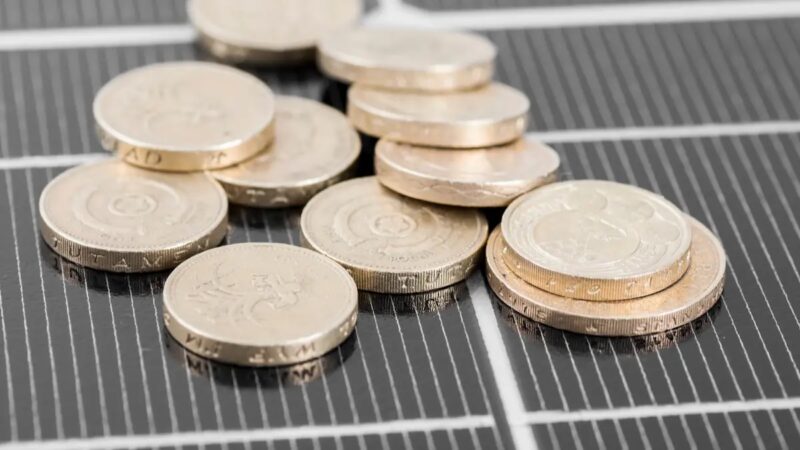 Geldmünzen auf einer Photovoltaik-Anlage.