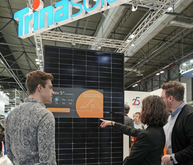 Messegäste betrachten das schwarze Solarmodul Vertex S+ von Trina