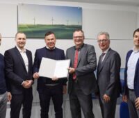 Die sechs Verantwortlichen mit dem Vertrag zum Ausbau der Ladeinfrastruktur in NRW in der Hand.