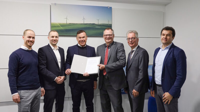 Die sechs Verantwortlichen mit dem Vertrag zum Ausbau der Ladeinfrastruktur in NRW in der Hand.