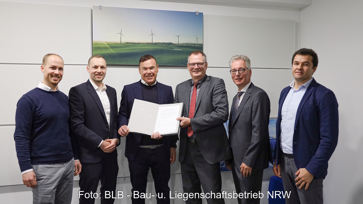 Die sechs Verantwortlichen mit dem Vertrag zum Ausbau der Ladeinfrastruktur in NRW in der Hand.