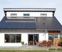 Einfamilienhaus mit Garten und PV-Anlage auf dem Schrägdach.