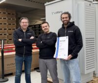 Im Bild Voltfang-Mitarbeiter vor einem Second-Life Batterie-Großspeicher.