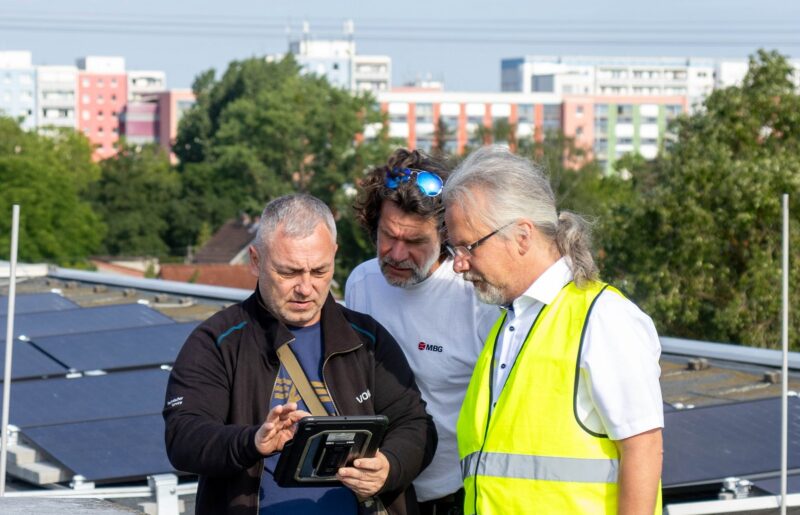 Im Bild drei Männer auf dem Dach, Vonovia hat ein Programm für Photovoltaik-Mieterstrom gestartet.
