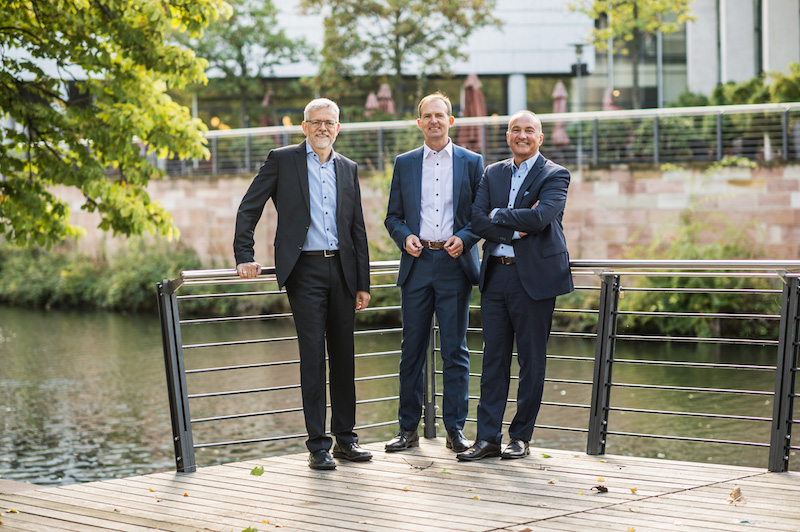 Die drei Vorstandsmitglieder der Umweltbank an einem Fluss