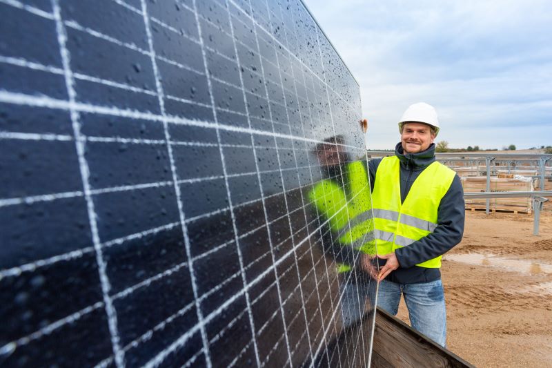 Ein Mitarbeiter der Wemag an einem PV-Modul einer Freiflächenanlage