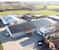 Luftaufnahme eines landwirtschaftlichen Betriebs mit Photovoltaik auf einem der Dächer.