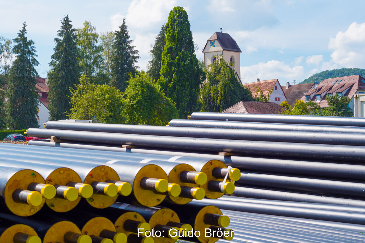 Fernwärmerohre vor Dorfkulisse in Breitenholz - Symbolbild für Infrastrukturinvestitionen von Kommunen nach dem LuKIFG