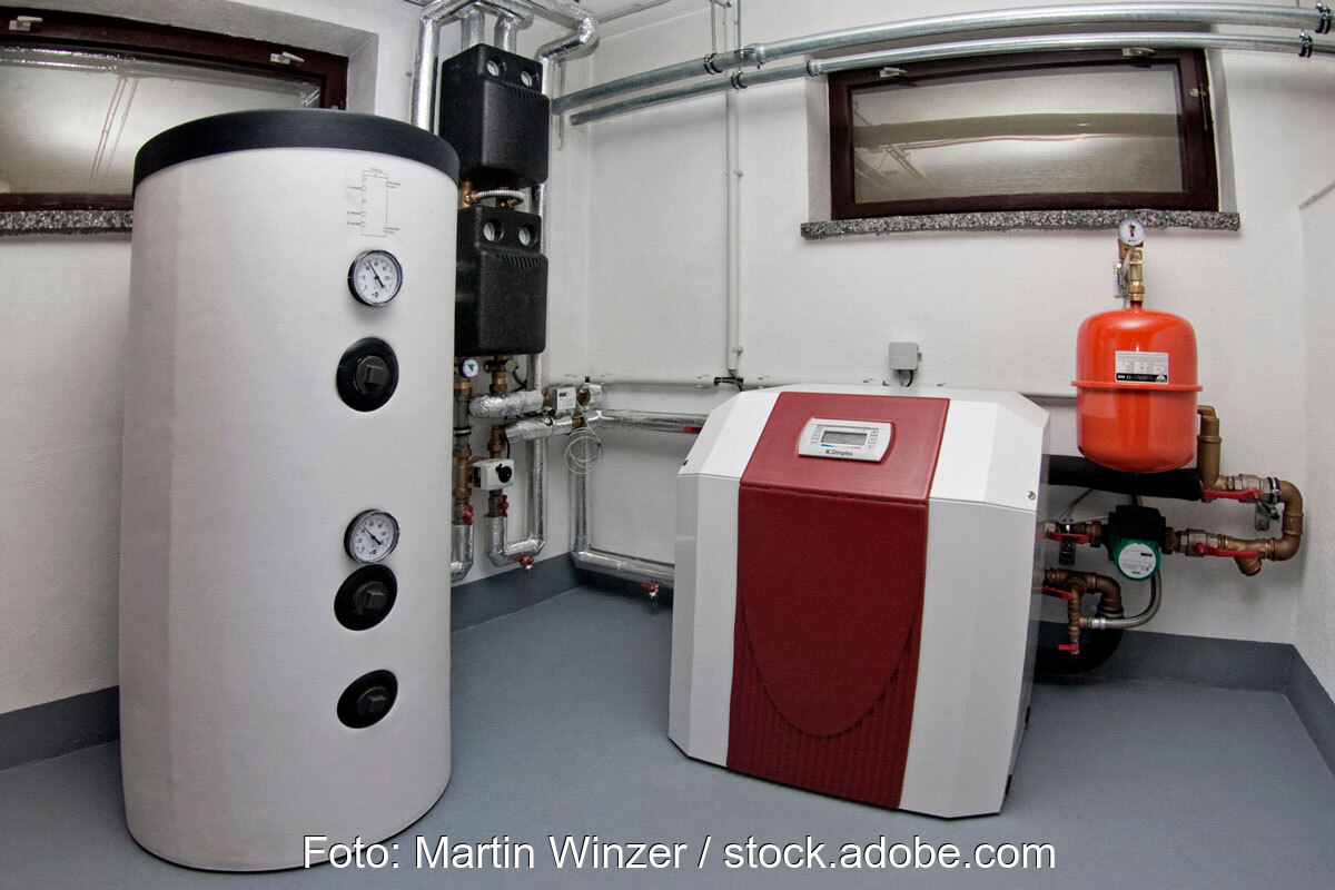 Wärmepumpe neben einem Pufferspeicher im Heizungskeller - Symbolbild für das GEG Gebäudeenergiegesetz